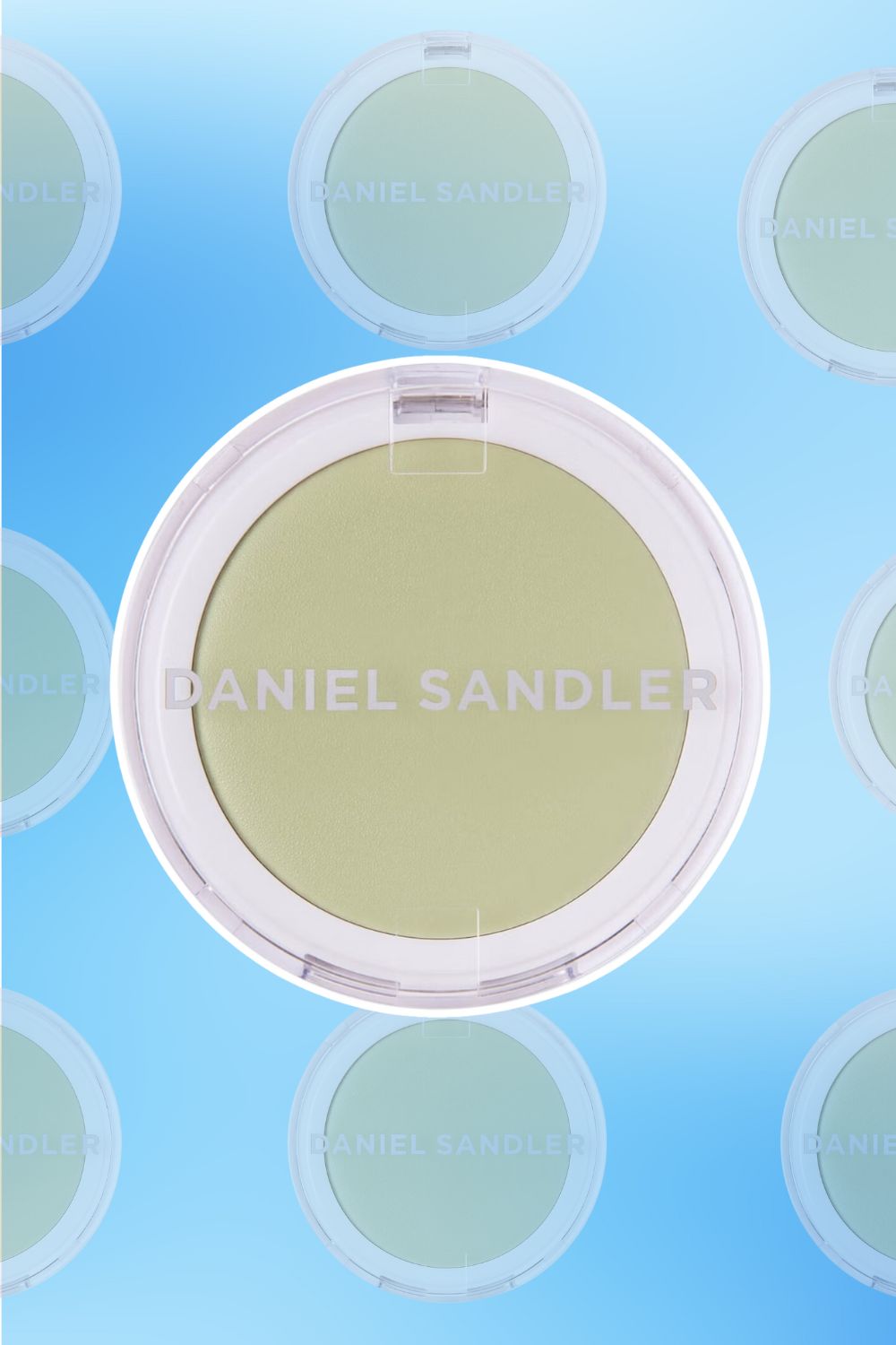 Daniel Sandler green face powder in a circular container on a blue background.