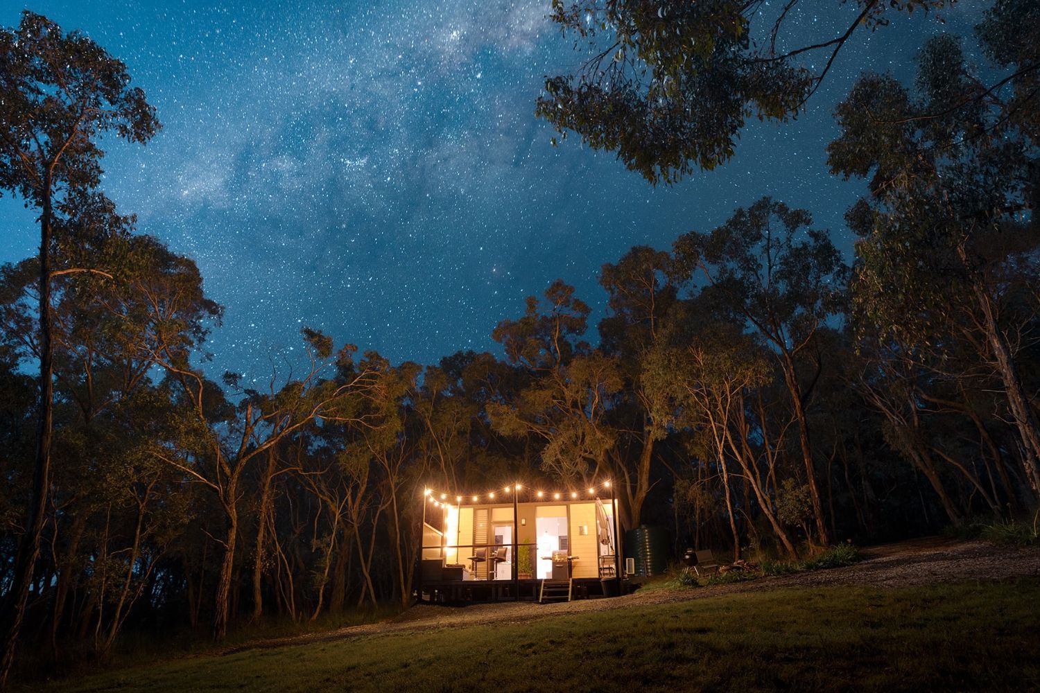 Serenity Abode tiny home lit up with fairylights at night