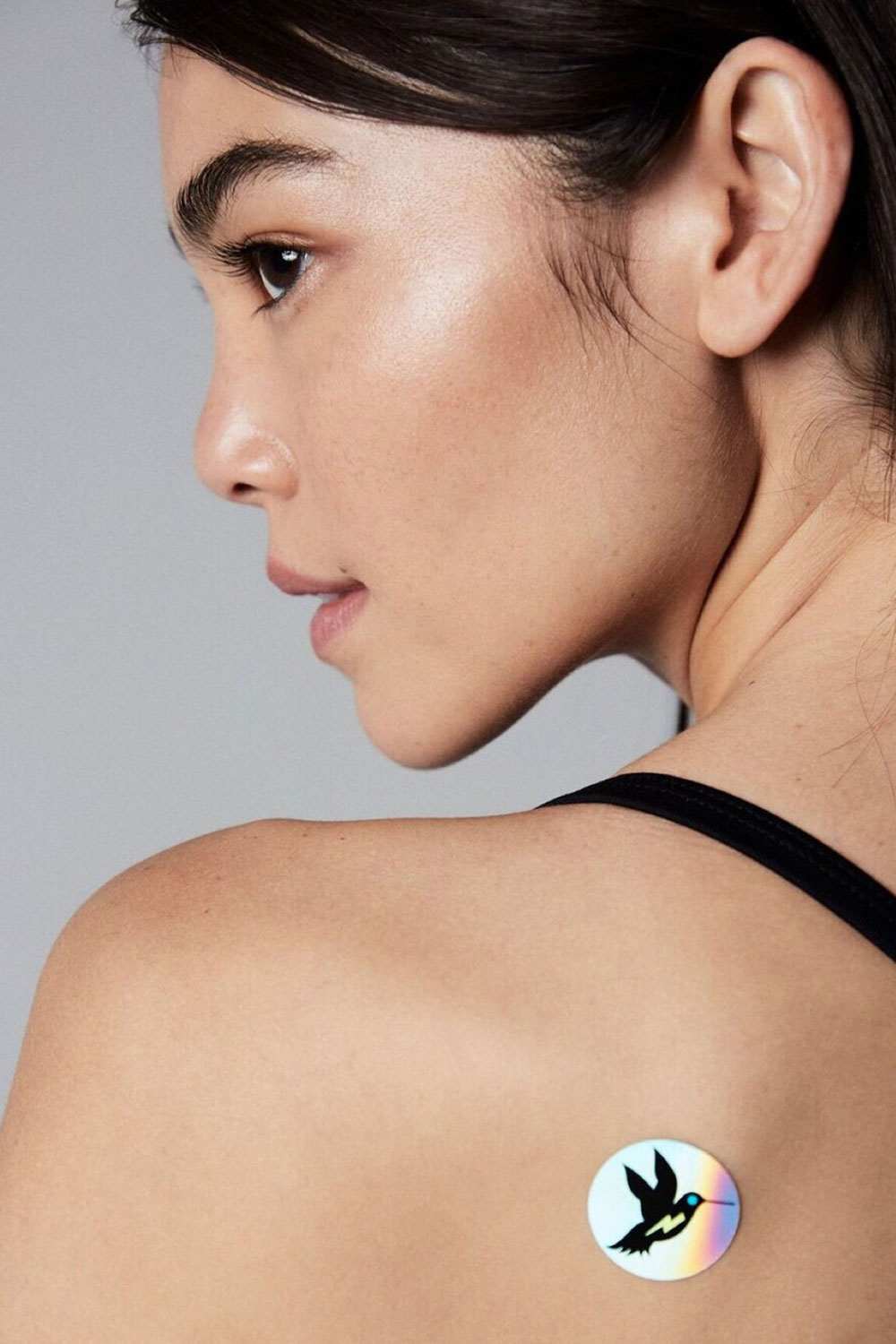 A-women-wearing-an-energy-frequency-sticker-by-mads.and.les-on-her-shoulder-blade