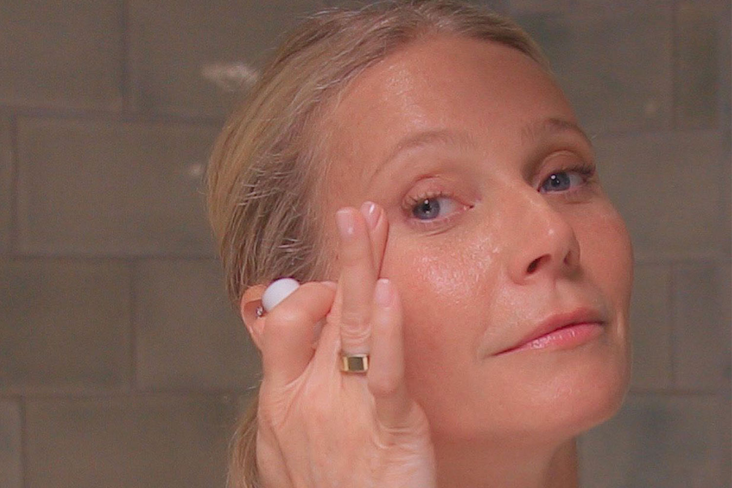 Gwyneth-paltrow-close-up-of-her-face-applying-skincare-produce